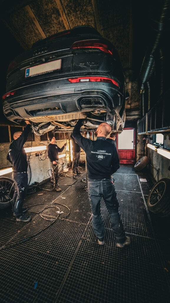 Holdet hos Låsby Rustbeskyttelse er i gang med at undervognsbehandle en bil